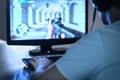 E sports and gaming concept. Gamer playing FPS video game with computer and wearing headphones. Professional videogame player. Royalty Free Stock Photo