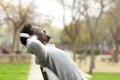 Black man with headphones listening to music on a bench Royalty Free Stock Photo