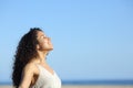 Relaxed young woman breating and enjoying sun on the beach