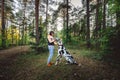 Woman exercising with Dalmatian dog in forest Royalty Free Stock Photo