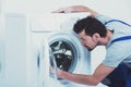 Side view of repairman checking washing machine.