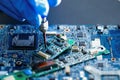 E-waste, technician repairing inside of hard disk by soldering iron. Integrated Circuit. Royalty Free Stock Photo