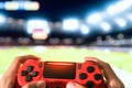 Young man having fun playing online soccer video games - Close up red magma game pad on tv background Royalty Free Stock Photo