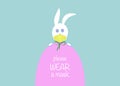 Easter egg and white bunny rabbit Wear a protective medical mask against covid-19. Coronavirus alert for Happy Easter card, banner
