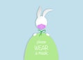 Easter egg and white bunny rabbit Wear a protective medical mask against covid-19. Coronavirus alert for Happy Easter card, banner