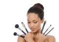 Each fulfills a different function. Beauty portrait of a young woman holding up make-up brushes.