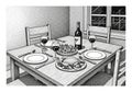 Each setting includes a plate, knife, and fork with a glass of red wine Royalty Free Stock Photo