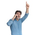 Eager casual man talking on his phone and pointing up