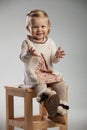 Eager little girl is sitting on a chair