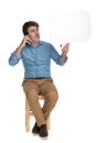 Eager man talking on phone and looking at speech bubble