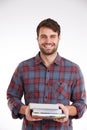 Always eager to learn. Studio portrait of a smiling young man holding a pile of books. Royalty Free Stock Photo