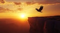 Eagle soaring over a cliff at sunset with golden light illuminating the landscape view Royalty Free Stock Photo