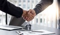 Eal estate agents and customers shake hands to congratulate on signing a contract to buy a house with land and insurance