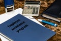 The EAP employee assistance program is written on a blue book lying on a marble Desk in the office