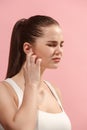 The Ear ache. The sad woman with headache or pain on a pink studio background. Royalty Free Stock Photo