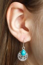 Ear with a beautiful earring with a turquoise stone Royalty Free Stock Photo