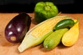 Ear of corn, with the husk pulled back, eggplant, jalapeÃÂ±o, and green bell pepper s and green and yellow squash Royalty Free Stock Photo