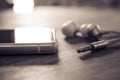 In-Ear Headphones And Cable Lying Next To A White Mobile Phone In Monochrome Colors Royalty Free Stock Photo