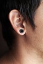 ear piercing,guy with a black tunnel in his ear Royalty Free Stock Photo