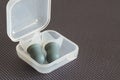 Ear plugs for swimming or diving in a small plastic box, isolated on grey background