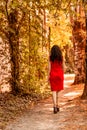 Ear view of woman in red, high heels and cocktail dress in wood Royalty Free Stock Photo