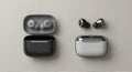 Earbuds and cases displayed on a light-textured surface. The left side features a set of grey Royalty Free Stock Photo