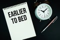 Earlier To Bed text written on notepad with pen and alarm clock Royalty Free Stock Photo