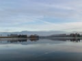 Early autumn morning, white mist over water and ground, beautifully colored and blurred tree silhouettes Royalty Free Stock Photo