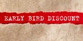 Early bird discount appearing behind torn paper.Business