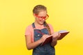Early child education. Portrait of creative smart little girl in bright red glasses writing in notebook