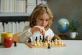 Early development. Child thinking about chess. The concept of learning and growing children. Chess, success and winning Royalty Free Stock Photo
