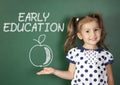 Early education concept, child girl near school blackboard