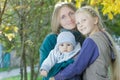 Early fall outdoor family portrait of cheerful mother with two siblings at yellow autumn shrubbery leaves background Royalty Free Stock Photo