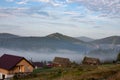 Early foggy morning in the mountains. Carpathians, Bukovel, lawn houses.