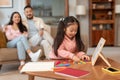 Korean Girl Playing Educational Games While Parents Relaxing At Home Royalty Free Stock Photo