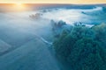 Early misty morning in the countryside. Sunrise over the river. Rural landscape in summer. Aerial view Royalty Free Stock Photo