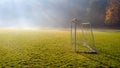 Early morning in the amatuer soccer field. Football game playground in autumn foggy morning. Sunlight in the background Royalty Free Stock Photo