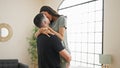 Early morning, beautiful couple enjoying a relaxed hug and a kiss in their comfortable bedroom, looking confident and happy in Royalty Free Stock Photo