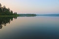 Early morning, calm water surface, fog over the lake. Summer landscape. Royalty Free Stock Photo