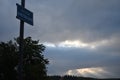 The early morning cloudy sky and the lamp post with the street plaque attached on it