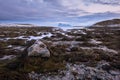 An early morning dreamy landscape photographed just before sunrise, including rocks, seaweed, water, snow, mountains and cloudy sk Royalty Free Stock Photo