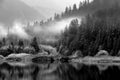 Early morning fog reflects on a lake in the mountains. Royalty Free Stock Photo