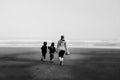 Early morning foggy beach family in black and white Royalty Free Stock Photo