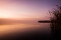 Early morning on the lake with a pink dawn and shrouded haze of mist, a mesmerizing mysticism of nature