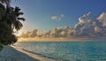 Early morning in the Maldives. The sun paints picturesque cumulus clouds with a golden hue.