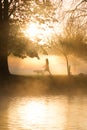 Early morning mist and fog over lake with passers by Royalty Free Stock Photo