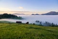 The early morning mist. Majestic spring day. A beautiful landscape with high mountains, sunset and sky with clouds. Dense fog with Royalty Free Stock Photo