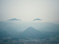 Early morning mist shrouds Yamagata, Japan, as peaks rise above. Twisting clouds add an aura of mystery and wonder.