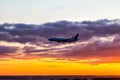 Early morning passenger airliner landing against the background of a colorful dawn sky. Jet plane silhouette Royalty Free Stock Photo