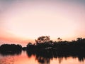 Early Morning on the river lake silhouette forest refection on water beautiful color of sunset sunrise nature background Royalty Free Stock Photo